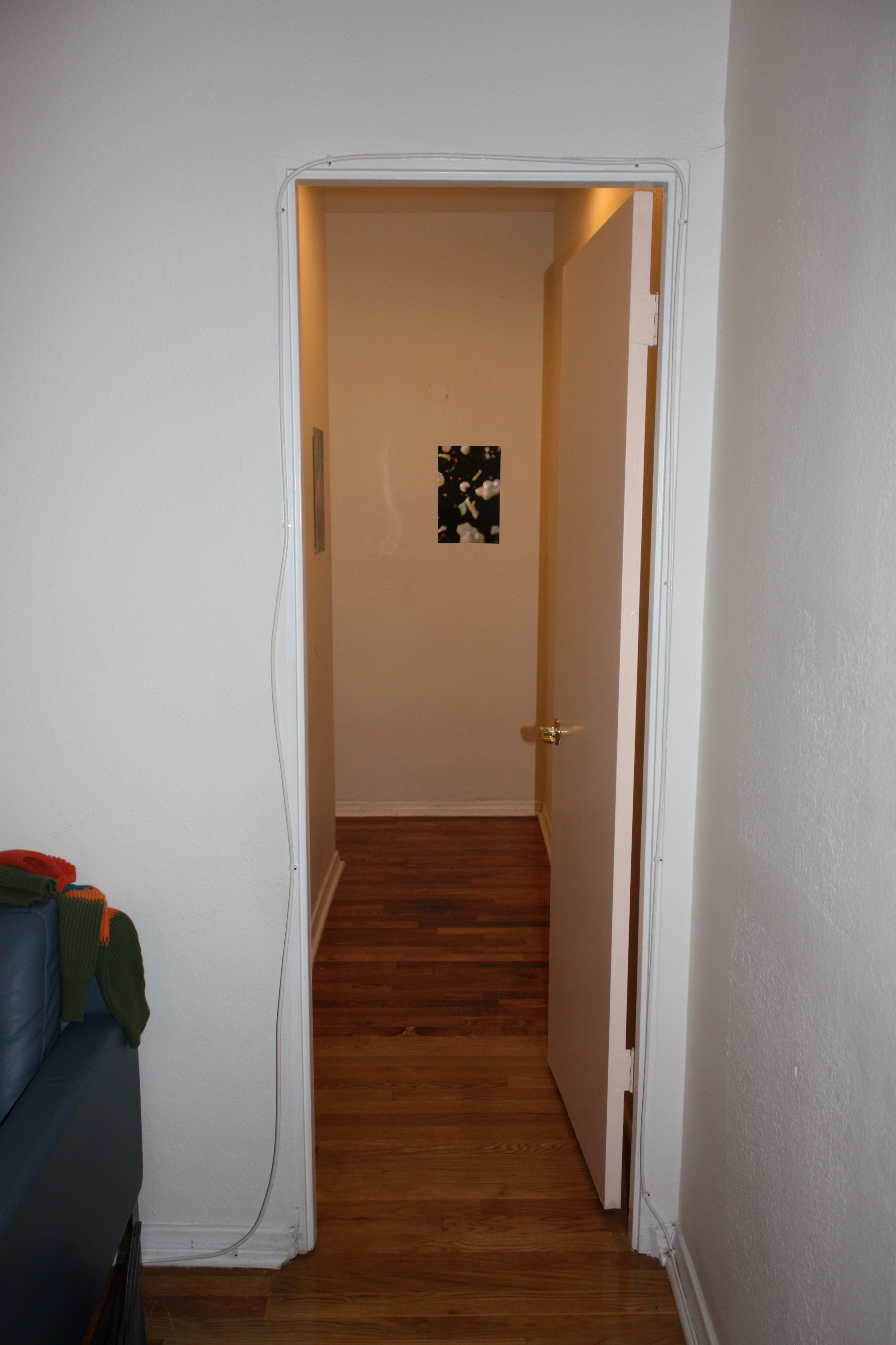 A narrow hallway with a small print hung on the wall